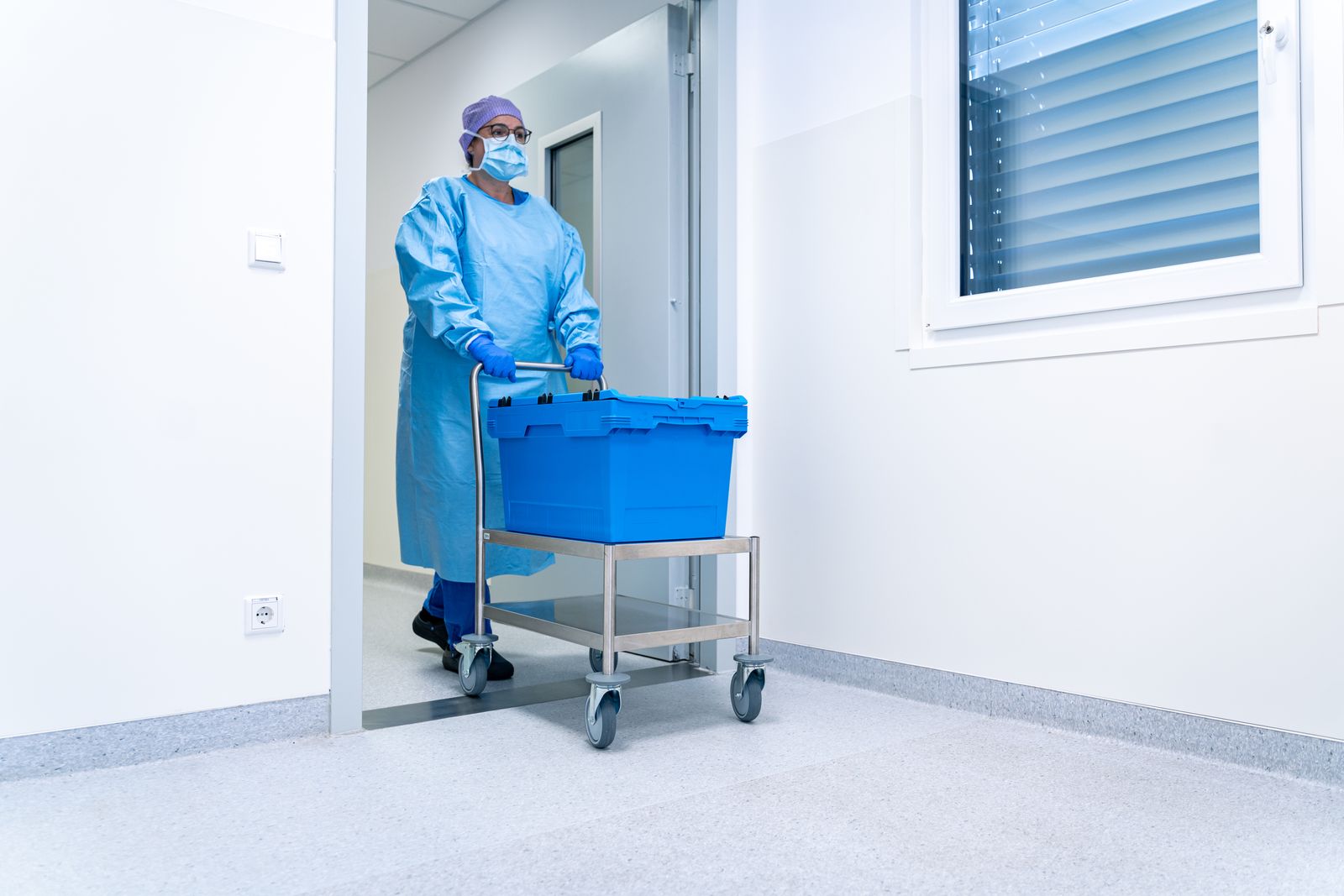 Mitarbeiterin bringt eine Transportbox mit Instrumenten in die AEMP